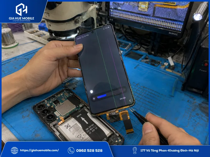Kỹ thuật viên kiểm tra mép màn hình và cáp Samsung Galaxy S23 Plus để xác định nguyên nhân gây sọc