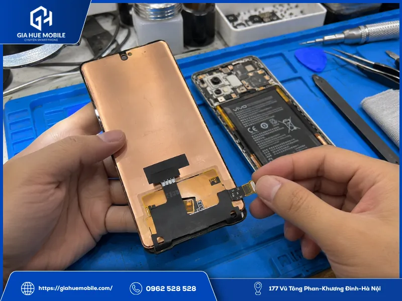 Kỹ thuật viên kiểm tra màn hình thay thế Vivo V30e trước khi lắp