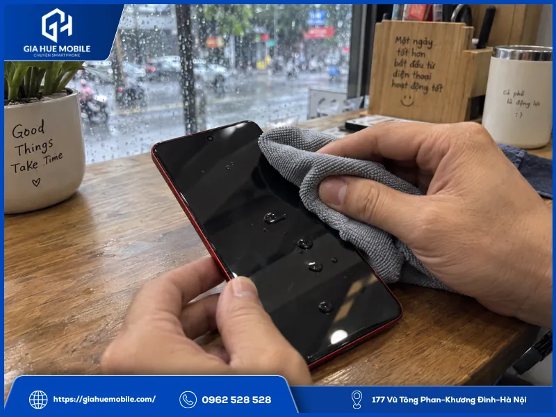 Người dùng lau khô Vivo iQOO Neo 9 sau ép kính khi máy vô tình dính vài giọt nước