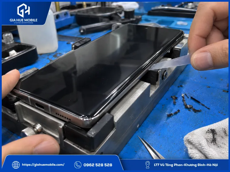 Kỹ thuật viên kiểm tra độ ôm khít mép màn Vivo X100 Pro sau khi xử lý lại keo viền