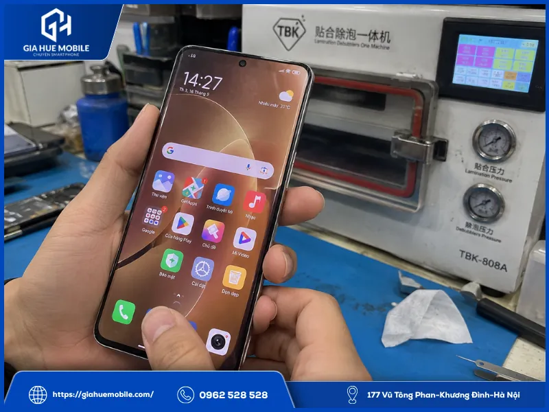 Kỹ thuật viên kiểm tra màn hình vân tay và mép kính Xiaomi sau khi ép kính